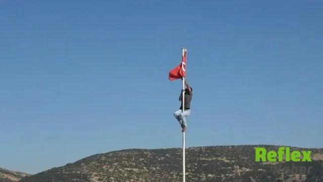Ravanda Kalesi’nde direğe dolanan Türk bayrağını tırmanarak düzeltti